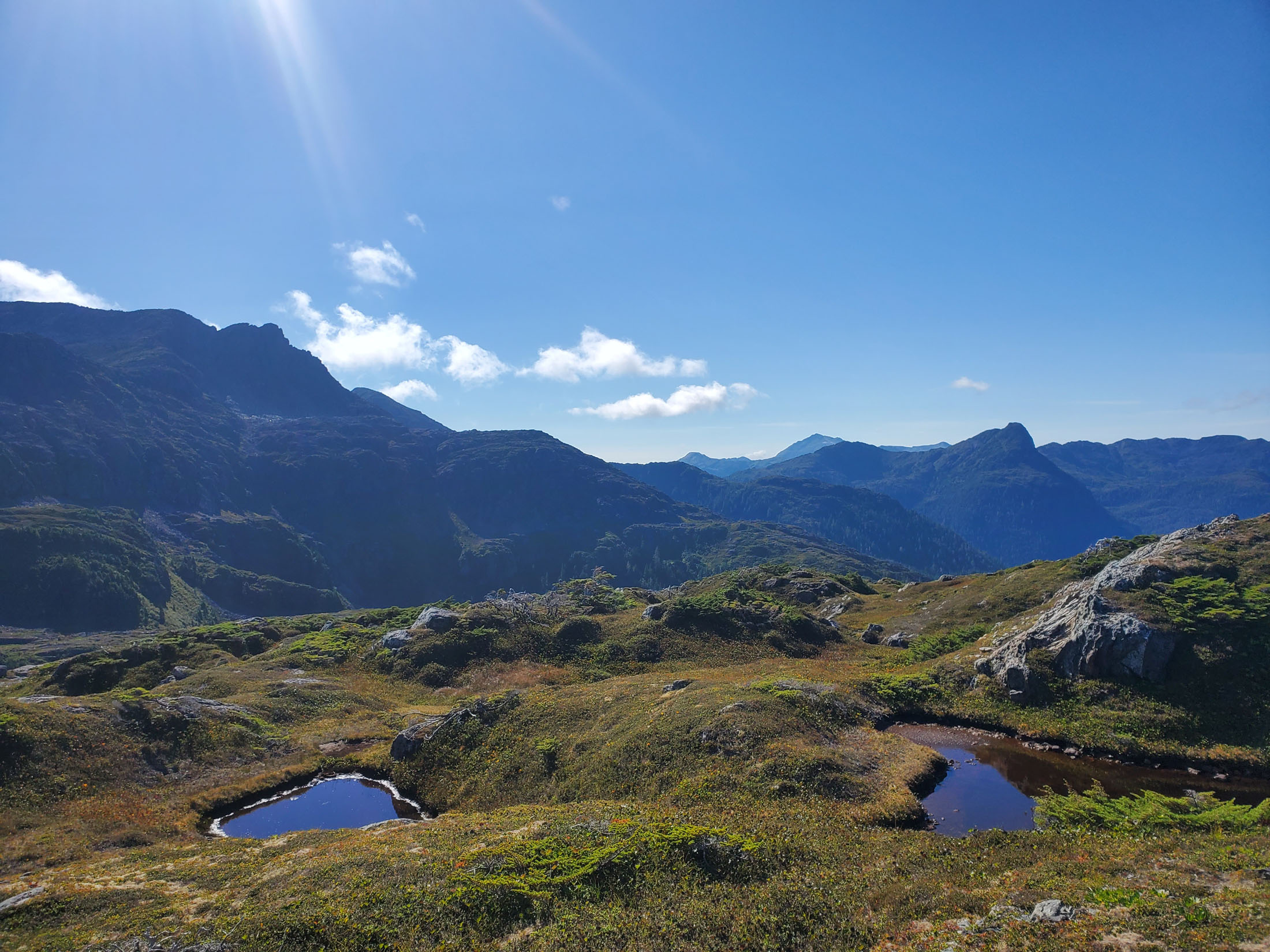 Mountain landscape with clear blue sky and ponds.